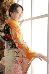 ファーストコレクション本庄早稲田店のスタジオの窓際でポーズをとっている黄色地と白の振袖を着た女性。成人式の前撮り撮影会の様子