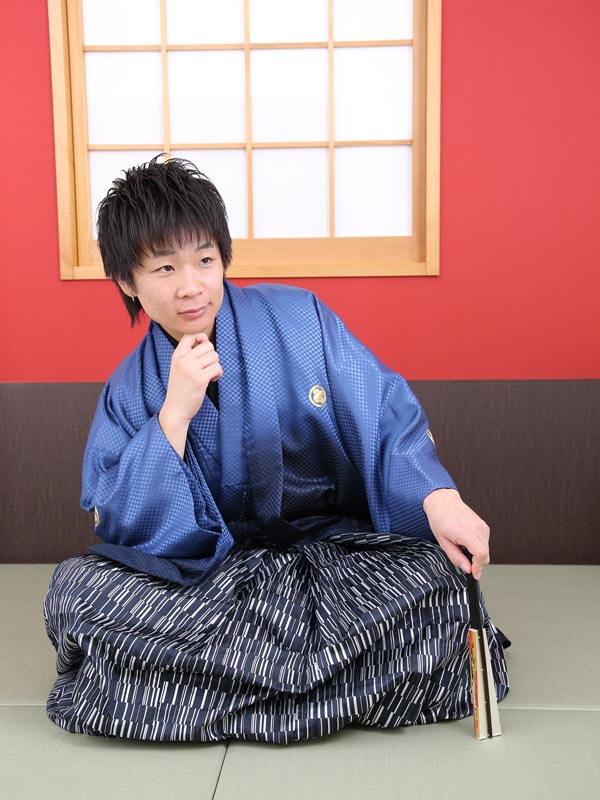 青い羽織、黒白の袴の成人男子袴を着た男性