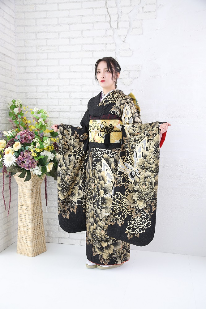 黒地にゴールド(金)の柄の振袖を着て立つ成人式前撮りの女性