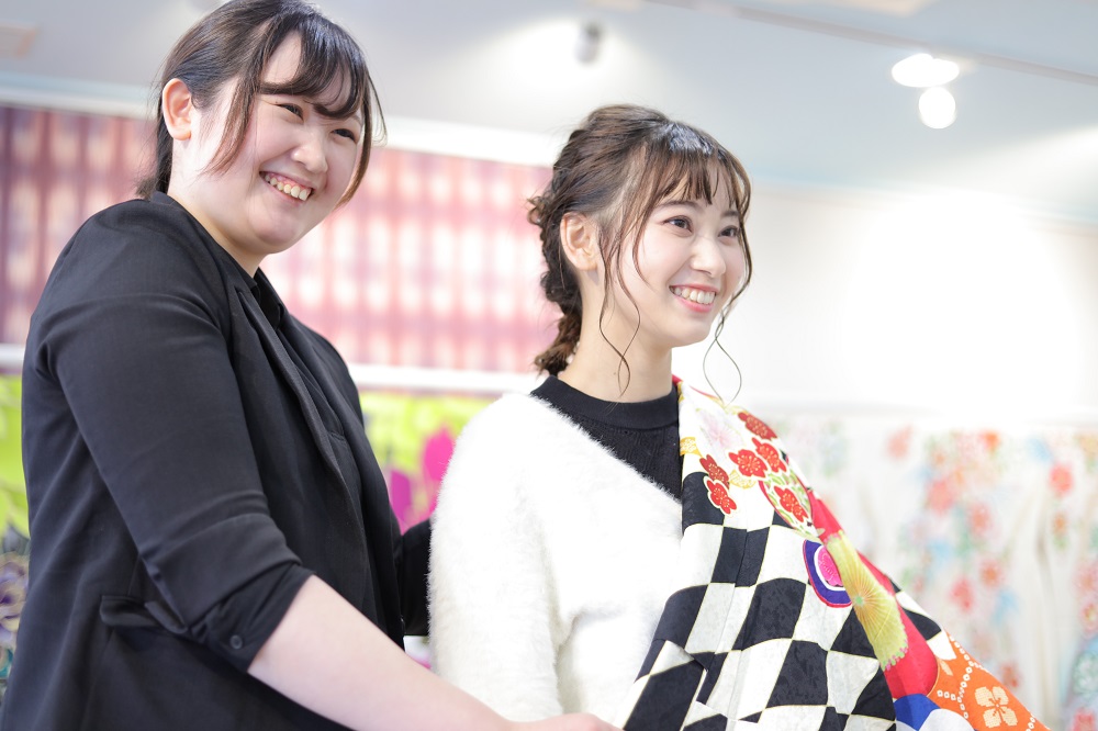 振袖を試着している二十歳の女性と店員