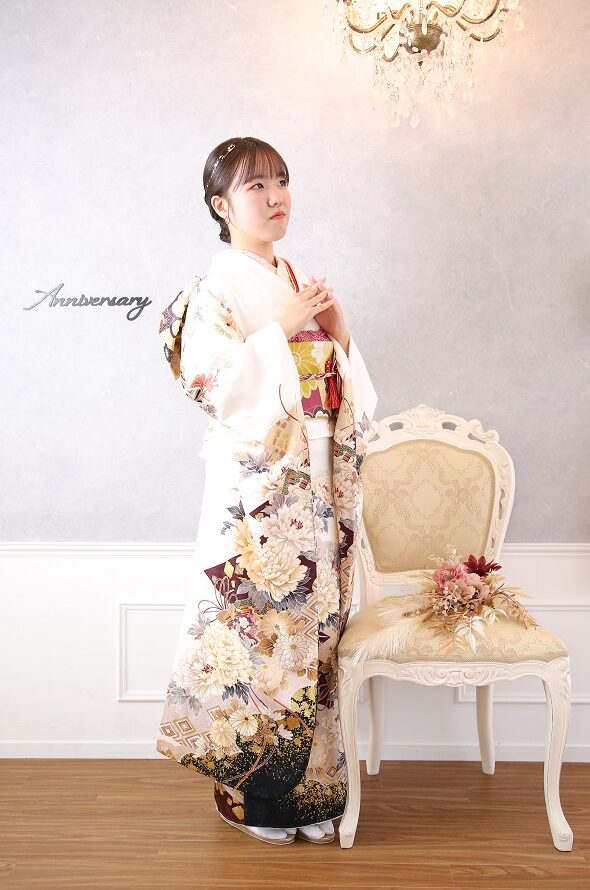 成人式の前撮りで白い振袖を着てポーズをとっている女性