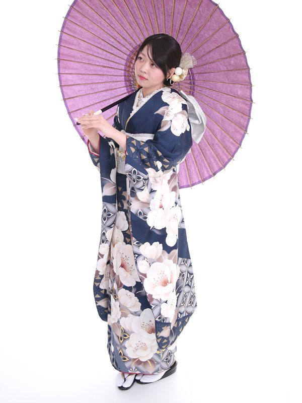 くすみカラーの紺地で椿柄の振袖を着た女性